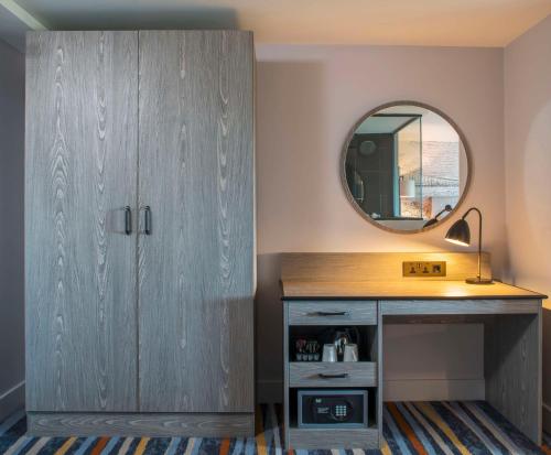a dressing room with a cabinet and a mirror at DoubleTree by Hilton Bristol South - Cadbury House in Yatton