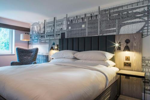 a bedroom with a large white bed and a chair at DoubleTree by Hilton Bristol South - Cadbury House in Yatton
