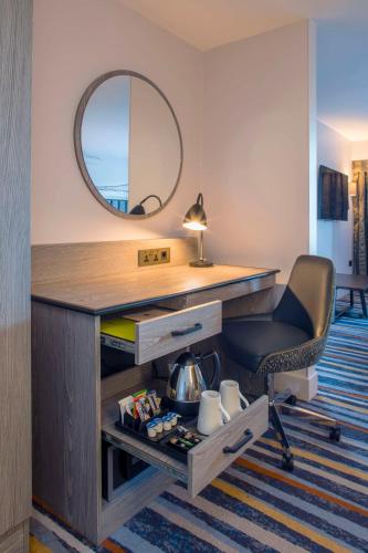 a desk with a chair and a mirror in a room at DoubleTree by Hilton Bristol South - Cadbury House in Yatton