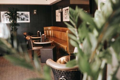 a waiting room with a table and chairs and plants at DoubleTree by Hilton Bristol South - Cadbury House in Yatton
