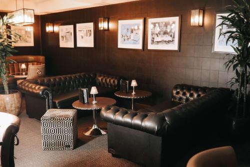 a restaurant with leather couches and tables and pictures on the wall at DoubleTree by Hilton Bristol South - Cadbury House in Yatton