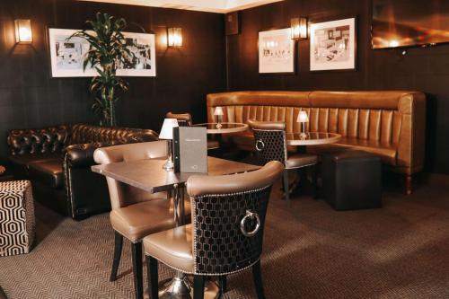 a restaurant with tables and chairs and a couch at DoubleTree by Hilton Bristol South - Cadbury House in Yatton