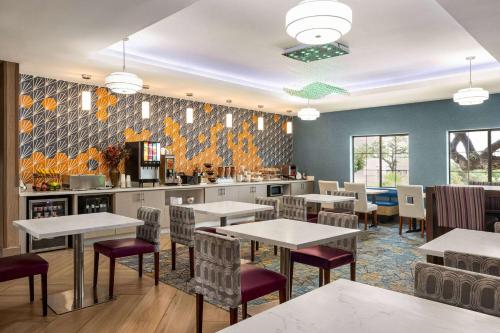 een restaurant met tafels en stoelen en een keuken bij La Quinta by Wyndham San Antonio North Stone Oak in San Antonio