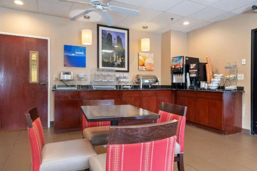 a restaurant with a bar with a table and chairs at Comfort Suites Lombard - Addison in Lombard