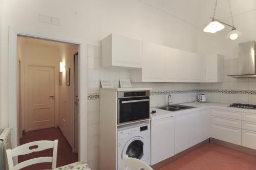 a kitchen with white cabinets and a dishwasher at Braschi Amalfi Dreams in Minori