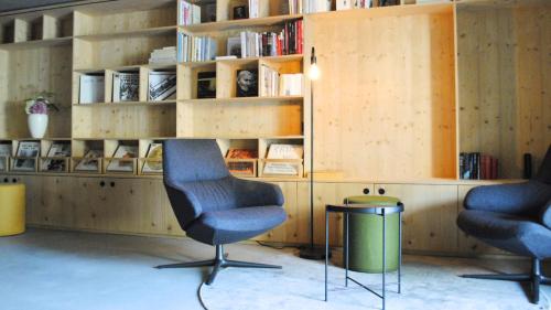 two chairs in a room with a book shelf at Boutique Hotel Casa Giovanoli in Tomils