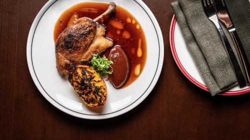 a plate of food with meat and vegetables on a table at Hotel Indigo Sydney Potts Point by IHG in Sydney