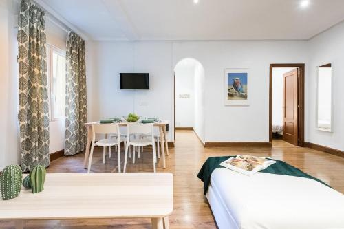 een slaapkamer met een bed en een eetkamer bij Apartamento totalmente equipado en el centro de Madrid in Madrid