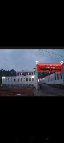 a building with a red sign in front of it at JK Home stay in Sultan Bathery