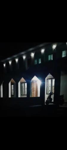 a building with a person sitting in front of it at night at JK Home stay in Sultan Bathery