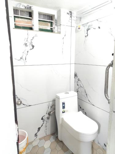 a white bathroom with a toilet in it at JK Home stay in Sultan Bathery