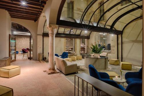 a lobby with chairs and tables and a building at NH Collection Palazzo Verona in Verona