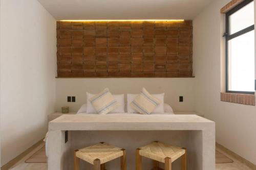 a bedroom with a bed with two stools at Aymara Punta Zicatela in Brisas de Zicatela
