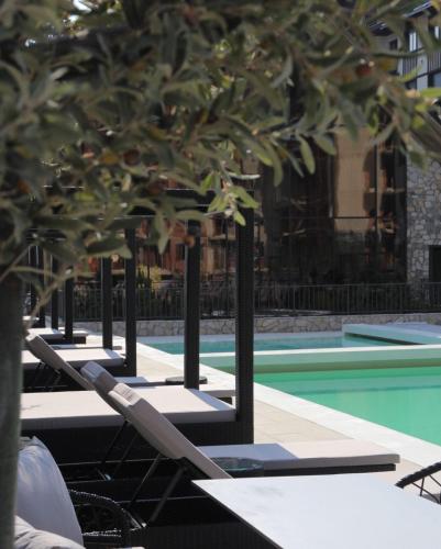 a row of lounge chairs next to a swimming pool at Adoro Titova Vila in Zlatibor