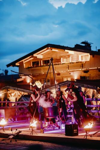 a group of people sitting on a stage with fire at Alpengasthof Hochsöll in Söll
