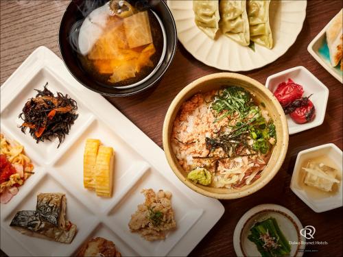 a table with plates of food and a bowl of food at Daiwa Roynet Hotel Sendai Nishiguchi PREMIER in Sendai