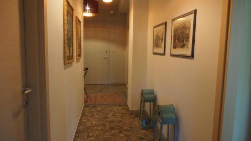 a hallway with two stools and paintings on the walls at Provenzale in Desenzano del Garda