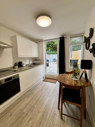 a kitchen with a wooden table and a dining room at Stylish and Chic Seaside Apartment in Southend-on-Sea