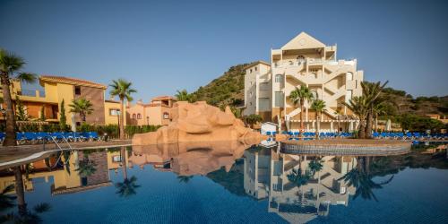 a resort with a reflection in a pool of water at Ona Lomas Village - La Manga Club in La Manga del Mar Menor