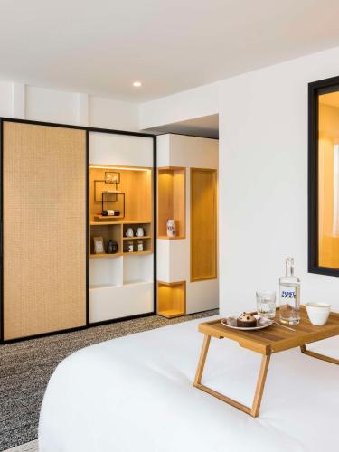 a living room with a table and a refrigerator at FirstName Bordeaux, Part of JdV by Hyatt in Bordeaux