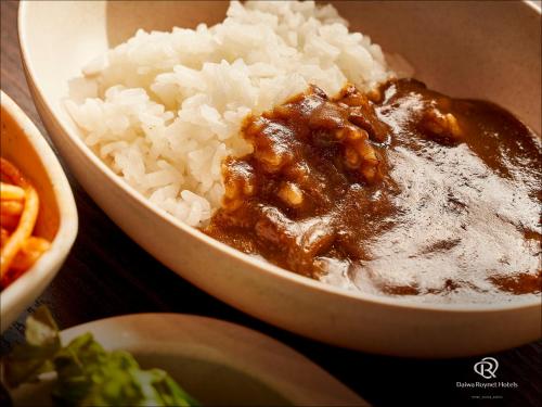a bowl of rice with sauce on top of it at Daiwa Roynet Hotel Sendai Nishiguchi PREMIER in Sendai
