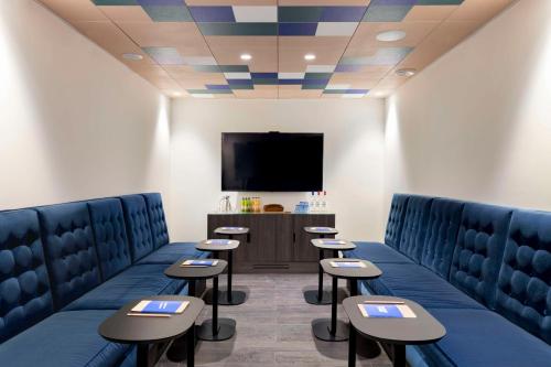 a waiting room with chairs and a flat screen tv at FirstName Bordeaux, Part of JdV by Hyatt in Bordeaux