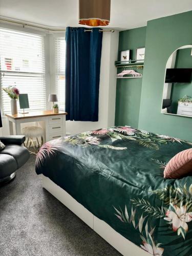 a bedroom with a bed and a desk at Stylish and Chic Seaside Apartment in Southend-on-Sea