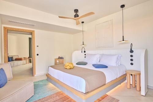 a bedroom with a large white bed with blue pillows at Paralos Kosta Alímia in Hersonissos
