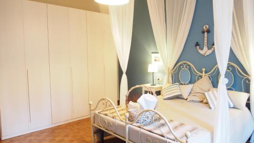 a bedroom with a white bed with a blue wall at Provenzale in Desenzano del Garda