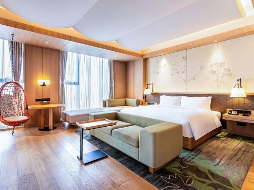 een hotelkamer met een bed en een bank bij Swissotel Xi' an Xinxing Hot Spring in Xi'an