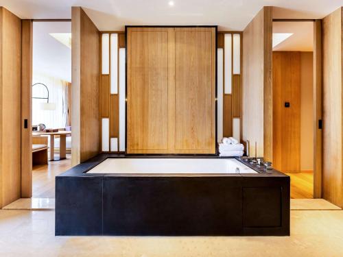 een badkamer met een groot bad in een kamer bij Swissotel Xi' an Xinxing Hot Spring in Xi'an