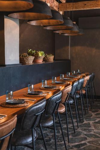 a long wooden table with chairs and wine glasses at Ona Lomas Village - La Manga Club in La Manga del Mar Menor
