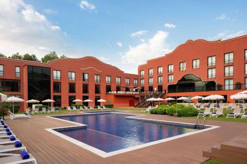 een hotel met een zwembad voor een gebouw bij Dolce by Wyndham Barcelona Resort in Sant Esteve Sesrovires