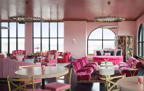 a room with pink chairs and tables and windows at Graduate by Hilton Nashville in Nashville