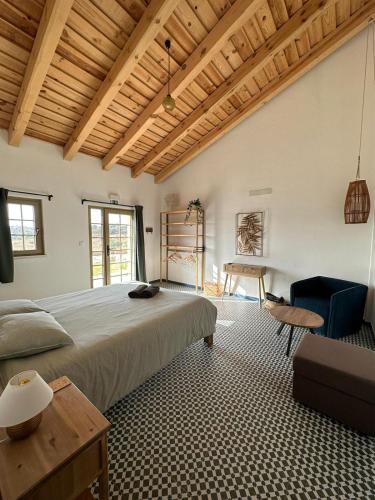 a bedroom with a large bed and a table at Alpaca Farm And B&B - Mama Adama in Grândola