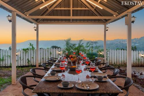 a long table with wine glasses on a patio at EKOSTAY Gold - White Swan Villa 6BHK in Panchgani