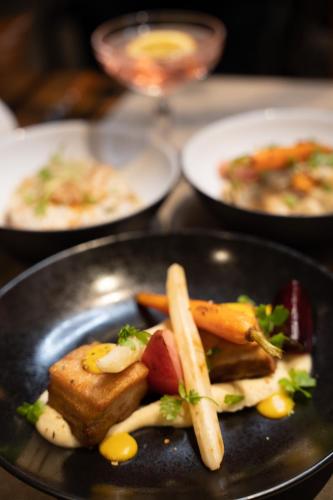 a plate of food with vegetables on a table at Annapurna by Alpine Resorts in Les Gets