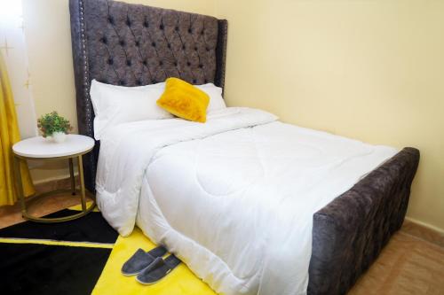 a bedroom with a large bed with a yellow pillow at Palisades in Voi