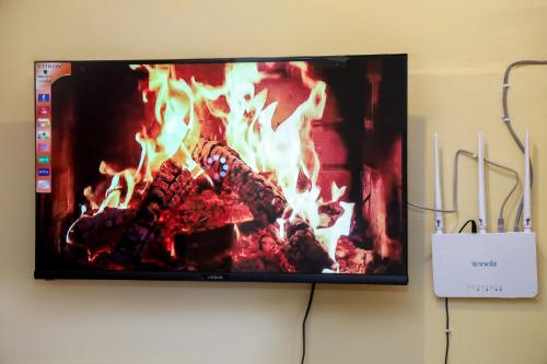 a flat screen tv hanging on a wall with a fireplace at Palisades in Voi