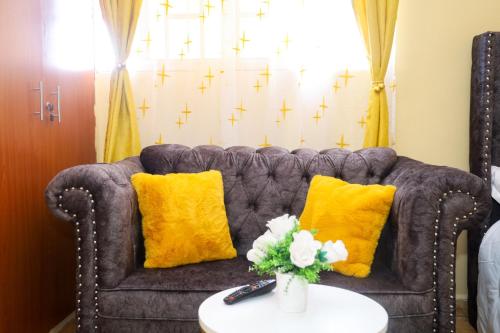 a living room with a couch and yellow pillows at Palisades in Voi
