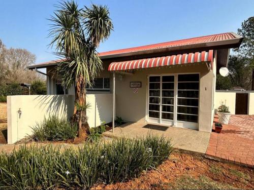 a small house with a palm tree in front of it at No 1 on Springfield in Winterton