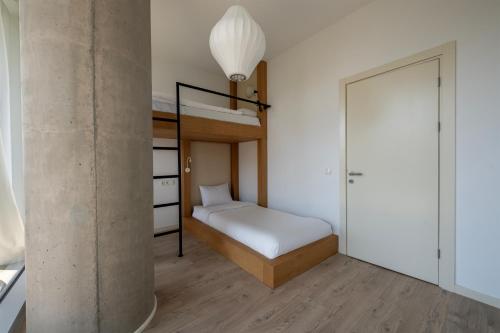 a small bedroom with a bunk bed and a staircase at Green Cape Botanico in Batumi