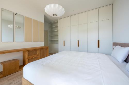 a bedroom with a large white bed and a desk at Green Cape Botanico in Batumi