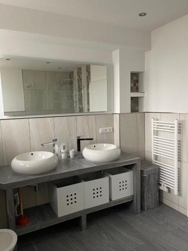 a bathroom with two sinks and a large mirror at Ferienwohnung im Spessart-Steinbach in Lohr