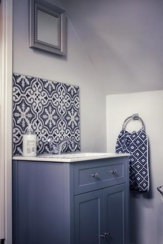 a bathroom with a blue cabinet and a mirror at Cosy One Bed Barn Conversion Donington Park East Midlands Airport in Derby