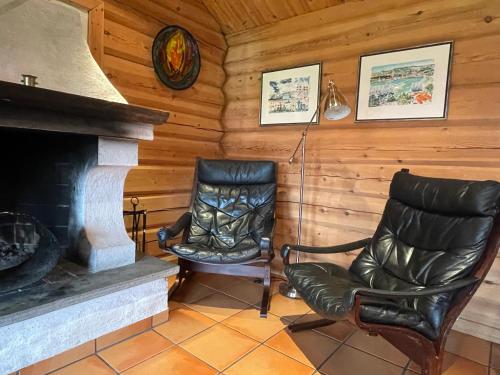 a living room with two chairs and a fireplace at Rondane Sollia Friluftsliv Øvre Nordli in Sollia