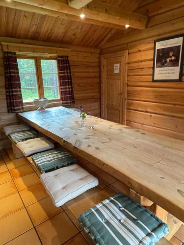 a wooden room with a table in a cabin at Rondane Sollia Friluftsliv Øvre Nordli in Sollia