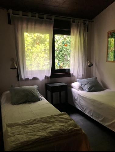 a bedroom with two beds and a window at Casa Maragota, La casa de Portocelo in Jove