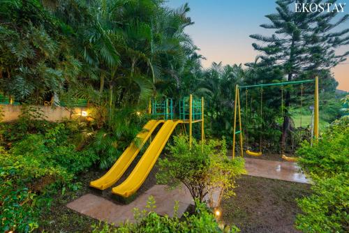 a playground with a yellow slide in a park at EKOSTAY Gold - White Swan Villa 6BHK in Panchgani