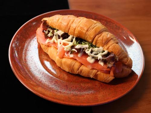 a sandwich on a plate on a table at Cloud Tree Inn Boutique Guesthouse XiChong DaPeng ShenZhen 深圳大鹏西涌云树里民宿Yun Shu Li in Shenzhen